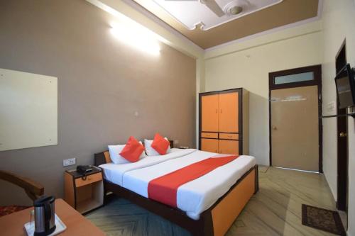 a hotel room with a large bed with red pillows at Hotel Sky Inn in Jaipur