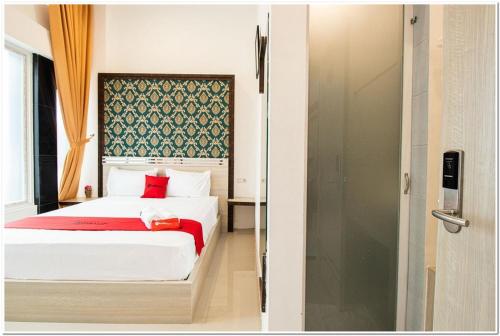 una camera con letto e doccia in vetro di RedDoorz Plus @ Centrium Katamso Medan a Medan