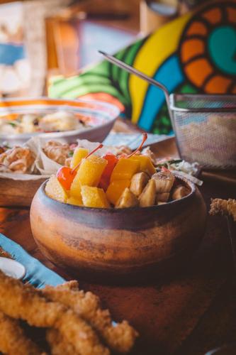 a table with a bowl of fruit and other food at Mad Monkey Hostel Nacpan Beach in El Nido