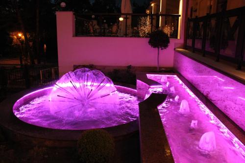 an umbrella in a pool with purple lights at Hotel Continental in Krynica Morska