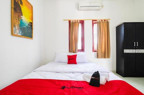 CimanggisにあるRedDoorz near Universitas Pamulangのベッドルーム1室(赤い毛布付きのベッド1台付)