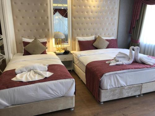 two beds in a hotel room with swans on them at Burj Al Istanbul in Istanbul