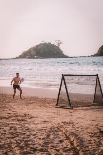 a man playing with a frisbee on the beach at Mad Monkey Hostel Nacpan Beach in El Nido