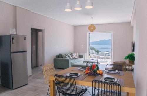 a kitchen and living room with a table and a refrigerator at Kalavria Luxury Suites - magnificent sea view of Poros in Poros
