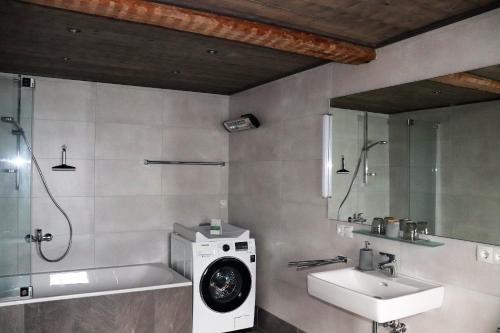 La salle de bains est pourvue d'un lave-linge et d'un lavabo. dans l'établissement Haus Neuwirt, à Sautens