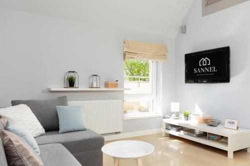 a living room with a couch and a table at Apartament Silver Międzywodzie in Międzywodzie