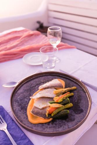 a plate with a sandwich and vegetables on a table at Sophia Luxury Suites in Imerovigli