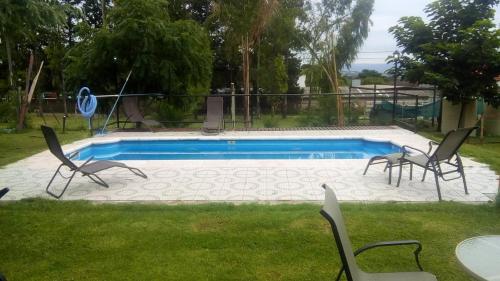 una piscina con 2 sillas y una mesa en Cabañas El Paraiso in 