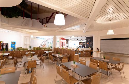 um restaurante com mesas e cadeiras e uma cafetaria em Jugend- und Familiengästehaus Klagenfurt em Klagenfurt