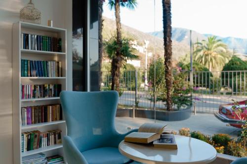 a library with a chair and a table with books at Sunrise Garden Hotel 3* in Gagra