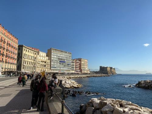 ナポリにあるHall inn B&B in Naplesの水辺歩道を歩く人々