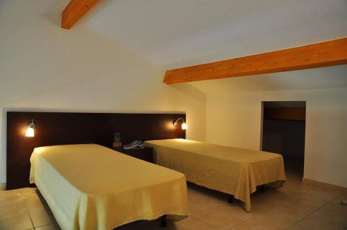 sypialnia z 2 łóżkami w pokoju w obiekcie Résidence Goélia Perla D'Isula w mieście Linguizzetta