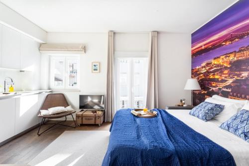 Cet appartement comprend une chambre avec un lit bleu et une cuisine. dans l'établissement ALTIDO Chic studio in Principe Real, nearby Botanical Garden of Lisbon, à Lisbonne