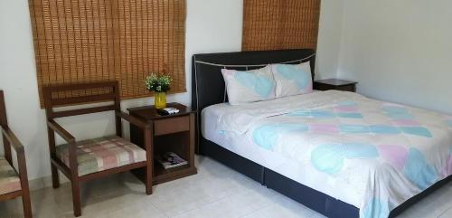 Kampong SelematにあるBukit Merah 99 Motel(Suria Apartment)のベッドルーム1室(ベッド1台、椅子、テーブル付)