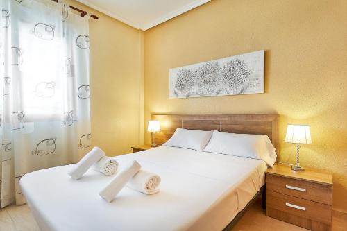 a bedroom with a large white bed with two pillows at Espanhouse La Zenia 109 in Orihuela Costa