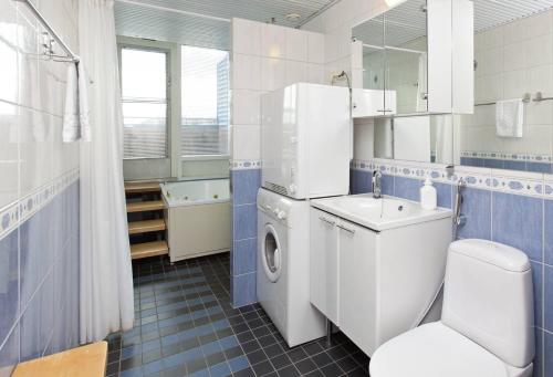 a bathroom with a white refrigerator and a sink and a toilet at Holiday Club Tampereen Kehräämö Apartments in Tampere