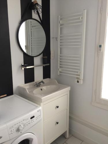 une salle de bain avec une machine à laver et un lavabo dans l'établissement Perigueux s'habille en noir et blanc, à Périgueux