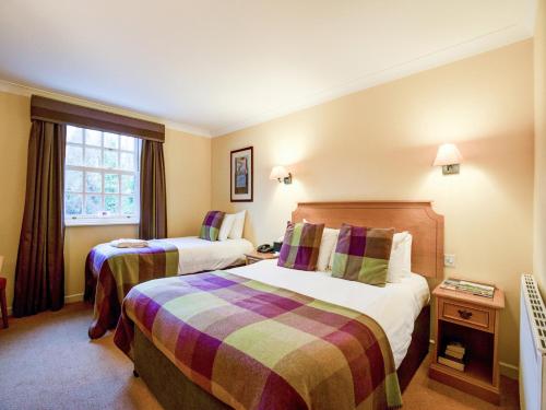 a hotel room with two beds and a window at Barony Castle Hotel in Peebles