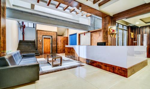 a lobby with a white counter and a staircase at Treebo Shree Sai Suites in Kolhapur