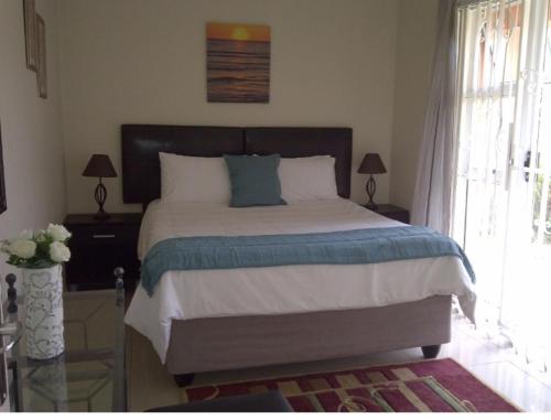 a bedroom with a large bed and a window at SunSet West Self Catering Maraisburg Roodepoort in Johannesburg