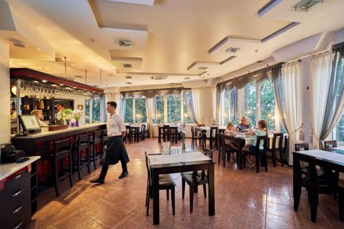 a man walking through a restaurant with people sitting at tables at Villa Oneiro in Alupka