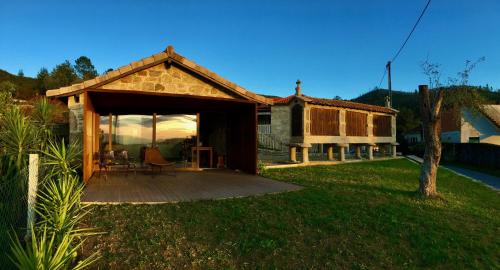 a house with a covered patio in the yard at Casa da Mina - Eido do Pomar in Arcos de Valdevez