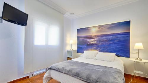 a bedroom with a bed with a painting on the wall at Casa Reyes El Palmar in El Palmar