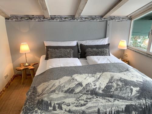 a bedroom with a large bed and two lamps at Apartment Lausbuam in Mühlbach am Hochkönig