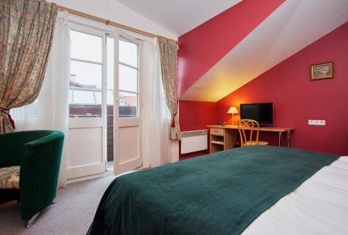 a room with a bed and a desk with a television at Angel Town Hall Apartments in Vilnius
