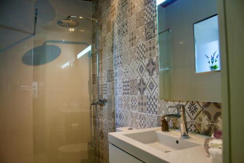 une salle de bain avec un lavabo, un miroir et une douche dans l'établissement Casa da Mina - Eido do Pomar, à Arcos de Valdevez
