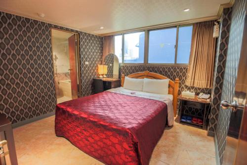 台北市にあるPai Yueh Hotelのベッドとバスルーム付きのホテルルームです。