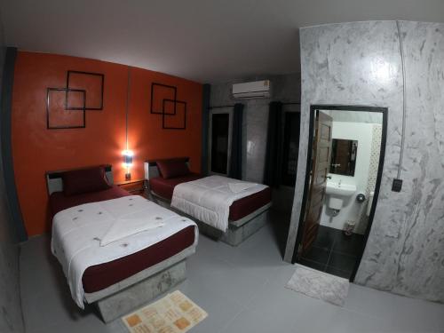 Janrawee Resort في Ban Phang Kan Nua: غرفة فندقية بسريرين ومرآة