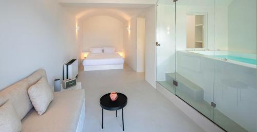 a bedroom with a couch and a bed and a bathroom at Old Castle Oia in Oia