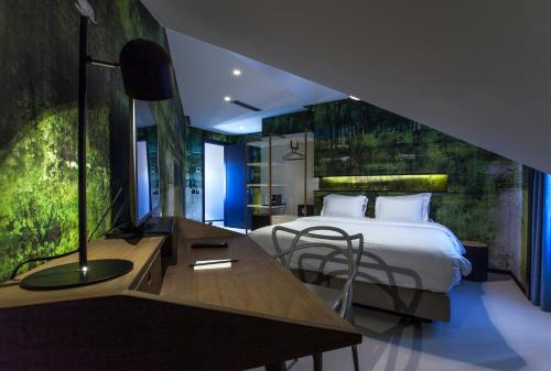 Hotel Pateo - Lisbon Lounge Suites في لشبونة: غرفة في الفندق مع سرير ومكتب مع مكتب