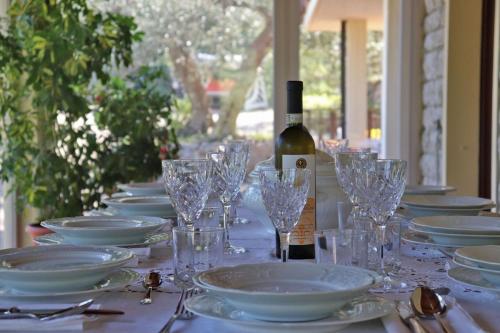a long table with plates and glasses and a bottle of wine at Villa Luisa in Pesaro