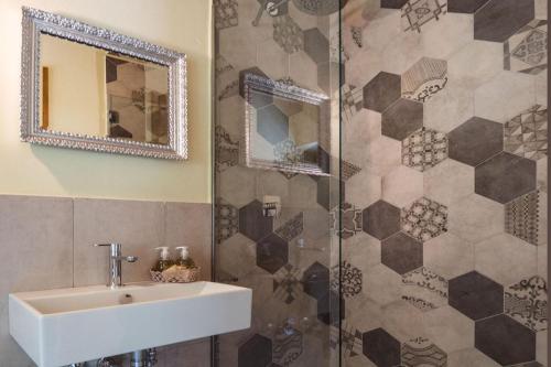 bagno con lavandino e doccia con specchio di Appartamento Nidastore ad Arcevia
