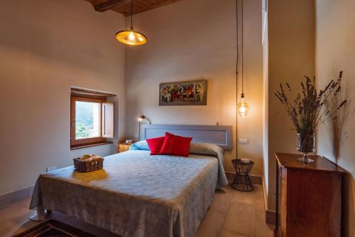 a bedroom with a bed with a red pillow on it at Appartamento Loretello in Arcevia