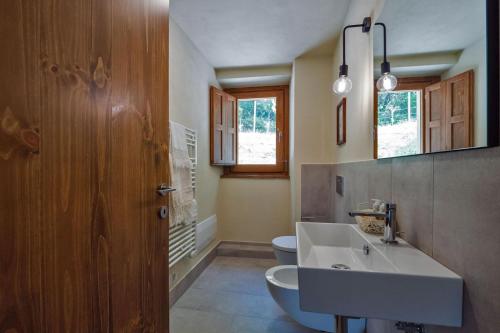a bathroom with a white sink and a toilet at Appartamento Loretello in Arcevia