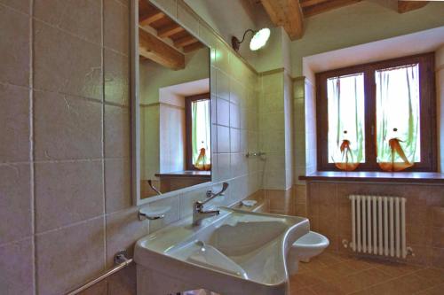 La salle de bains est pourvue d'un lavabo et d'un miroir. dans l'établissement Appartamento Indaco, à Cagli