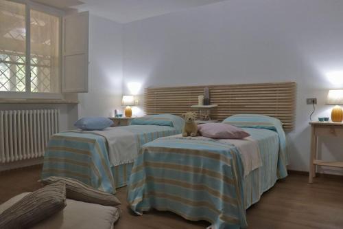 a room with three beds with a teddy bear sitting on them at Villa Luisa in Pesaro