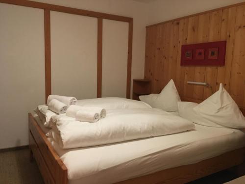 a bedroom with two beds with white sheets and towels at Haus Elisabeth Apartments in Obertauern