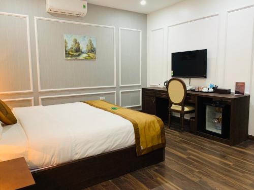 a bedroom with a bed and a desk and a television at Nice Dream Hotel in Yen