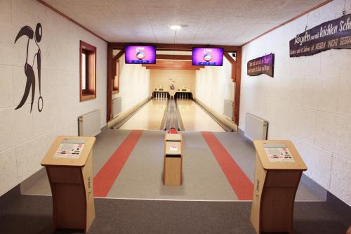 a bowling alley with two lanes and two tables at Hotel Gailberghöhe in Kötschach