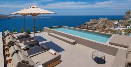 a villa with a swimming pool and a view of the ocean at Old Castle Oia in Oia