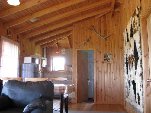a living room with wood paneled walls and a kitchen at Topahue in Ensenada