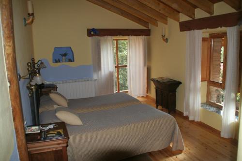 a bedroom with a bed in a room with windows at El Canto del Gallo in Ranedo de Curueño
