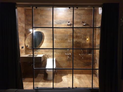 a bathroom with a shower with a toilet and a sink at Celebrations - Vagator - Goa in Vagator