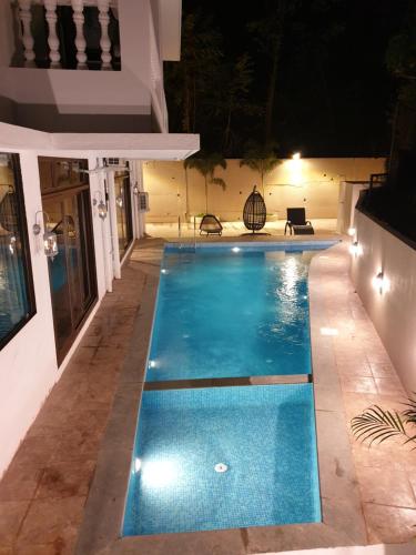 a swimming pool at night in a house at Celebrations - Vagator - Goa in Vagator