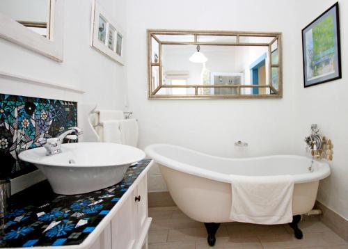 a white bathroom with a large tub and a mirror at Gilcrest Place Guest House in Paternoster
