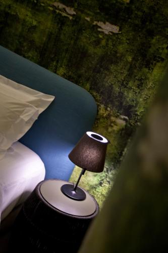 a small lamp sitting on a table next to a bed at Apartments Pateo - Lisbon Lounge Suites in Lisbon